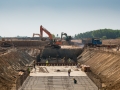 Close shot of heavy machines and construction workers working on a building