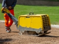 Construction worker working on the road with a vibratory plate